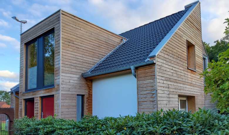 Die Klinkerfassade des Hauses verschwand hinter einer gedämmten Fassade aus Lärchenholz und das Haus besitzt zwei Haustüren