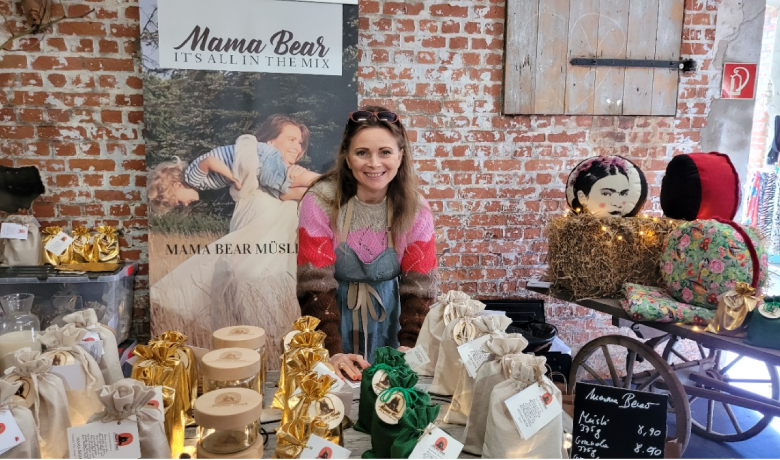 Ewa Helena Martin umgeben von diversen Produkten aus dem Mama Bear -Shop
