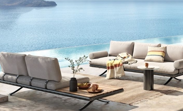 Weiche Stoffe und runde Formen verleihen dem auf geschwungenen Aluminiumfüßen ruhenden Outdoor-Sofa Eleganz