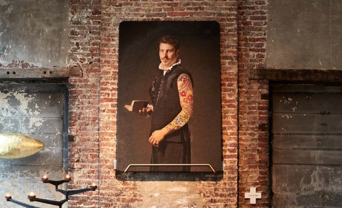 Ein Mann scheinbar aus dem Mittelalter mit einem tätowierten Arm